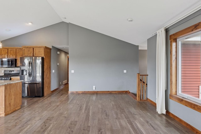 1664 Otter Way, New Richmond, WI 54017 - kitchen with appliances with stainless steel finishes, wood finished floors, brown cabinetry, light stone countertops, and tasteful backsplash