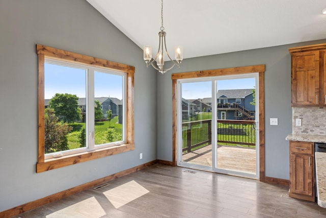 1664 Otter Way, New Richmond, WI 54017 - unfurnished dining area with a chandelier, wood finished floors, and lofted ceiling