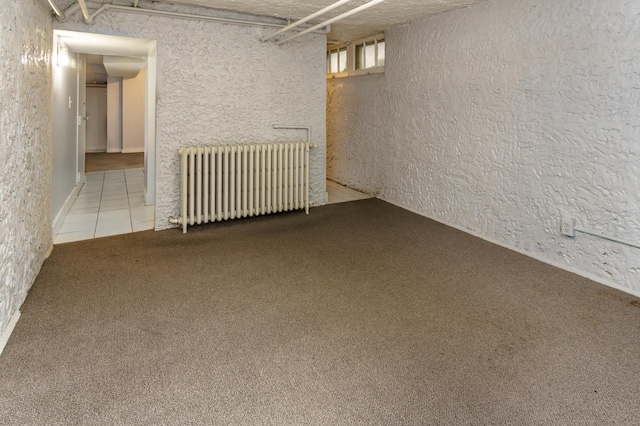 4720 Nicollet Ave Unit 5, Minneapolis, MN 55419 - finished below grade area featuring radiator, carpet, a textured wall, and tile patterned floors