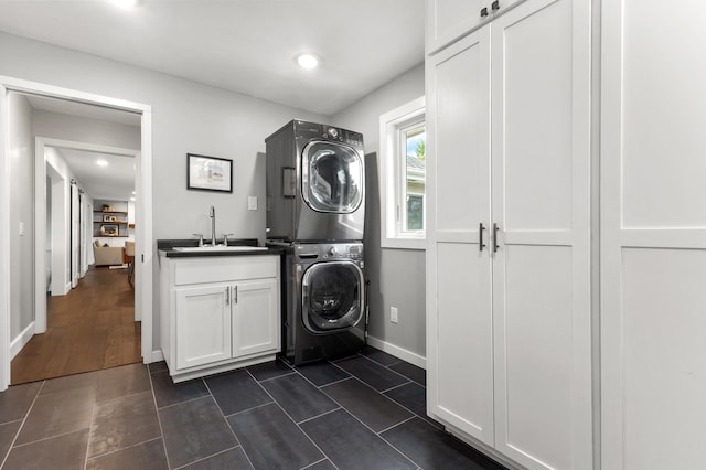 1541 Wexford Ct, Eagan, MN 55122 - laundry room with stacked washer and clothes dryer, cabinet space, dark tile patterned floors, and recessed lighting