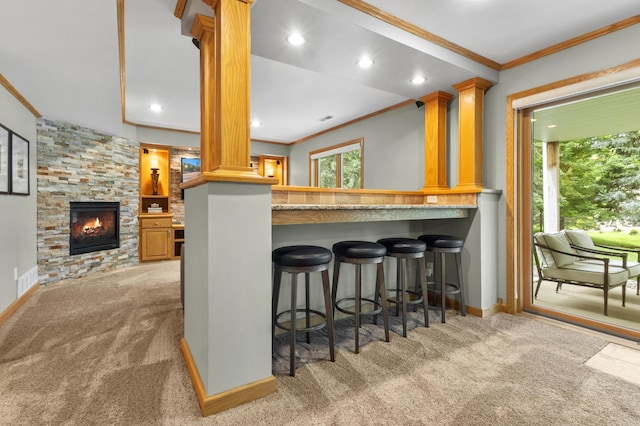 1541 Wexford Ct, Eagan, MN 55122 - kitchen featuring crown molding, carpet, a stone fireplace, a kitchen breakfast bar, and ornate columns