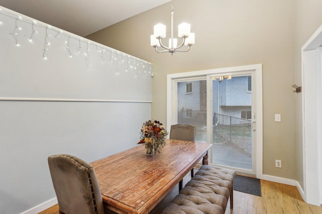 7467 Meadowwood Ct, Brooklyn Park, MN 55444 - dining room featuring a chandelier, light wood-type flooring, and a high ceiling