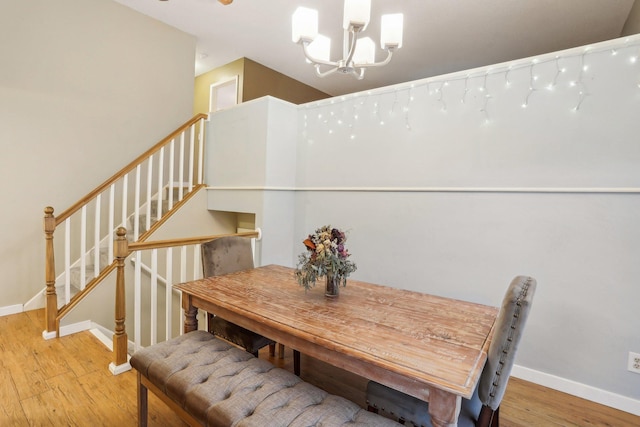 7467 Meadowwood Ct, Brooklyn Park, MN 55444 - dining space featuring a chandelier, wood finished floors, and stairway