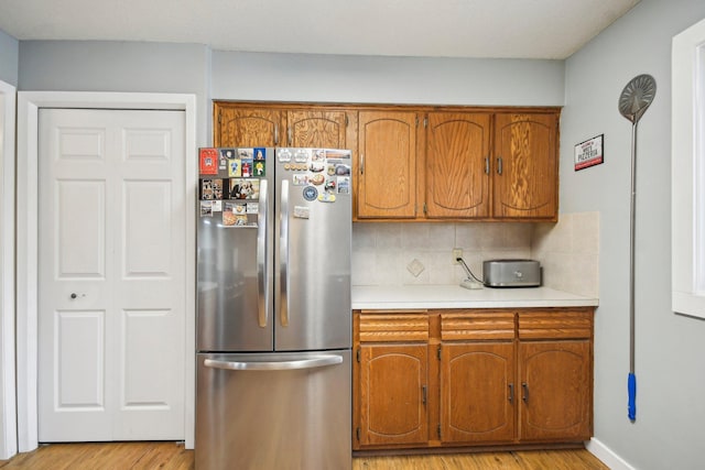 7467 Meadowwood Ct, Brooklyn Park, MN 55444 - kitchen with freestanding refrigerator, brown cabinets, and light wood-type flooring