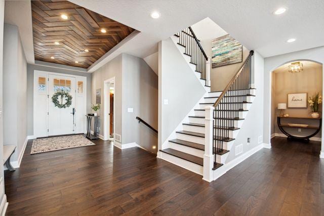 19803 Jersey Ave, Lakeville, MN 55044 - foyer entrance with a tray ceiling, hardwood / wood-style flooring, arched walkways, recessed lighting, and stairs
