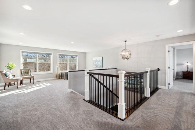 19803 Jersey Ave, Lakeville, MN 55044 - corridor with carpet floors, an upstairs landing, healthy amount of natural light, recessed lighting, and a chandelier
