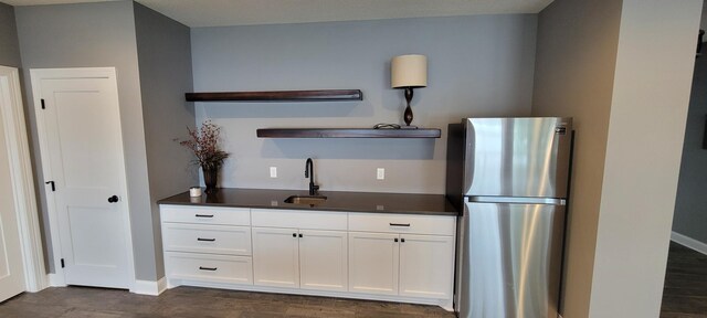 19803 Jersey Ave, Lakeville, MN 55044 - kitchen featuring freestanding refrigerator, open shelves, dark countertops, dark wood finished floors, and white cabinetry