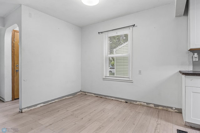 1130 Oak St N, Fargo, ND 58102 - unfurnished dining area with light wood-type flooring and arched walkways