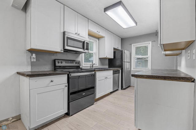 1130 Oak St N, Fargo, ND 58102 - kitchen with appliances with stainless steel finishes, dark countertops, light wood-type flooring, and plenty of natural light