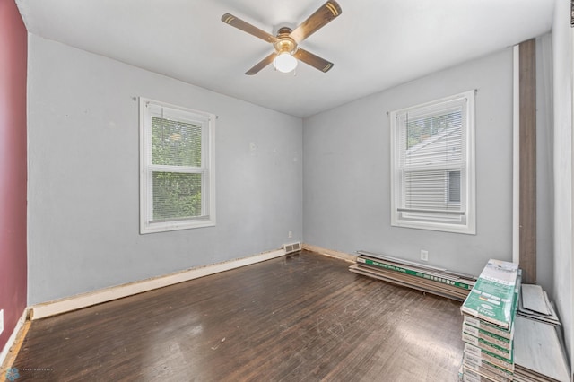 1130 Oak St N, Fargo, ND 58102 - empty room with healthy amount of natural light, ceiling fan, wood finished floors, and a baseboard radiator