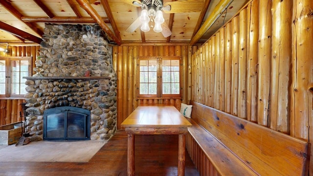 13000 Inlet Cir, Park Rapids, MN 56470 - unfurnished dining area featuring a ceiling fan, hardwood / wood-style floors, a wood ceiling with exposed beams, a fireplace, and wooden walls