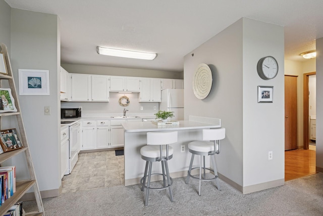 6500 Woodlake Dr Unit 1006, Richfield, MN 55423 - kitchen with white appliances, light carpet, light countertops, white cabinets, and a breakfast bar