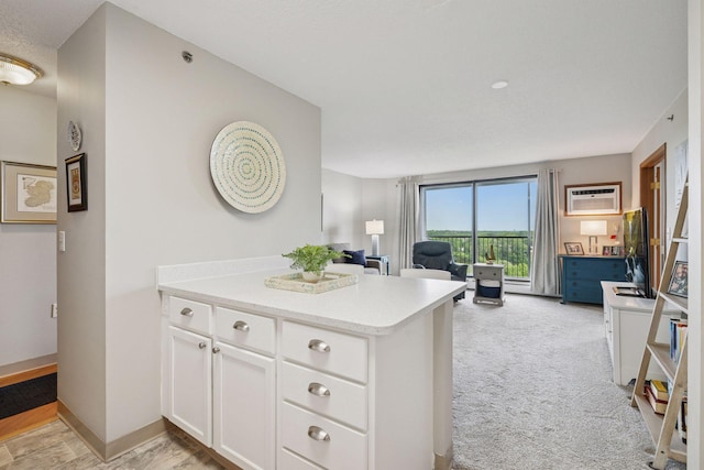 6500 Woodlake Dr Unit 1006, Richfield, MN 55423 - kitchen with open floor plan, white cabinets, light countertops, a peninsula, and light carpet