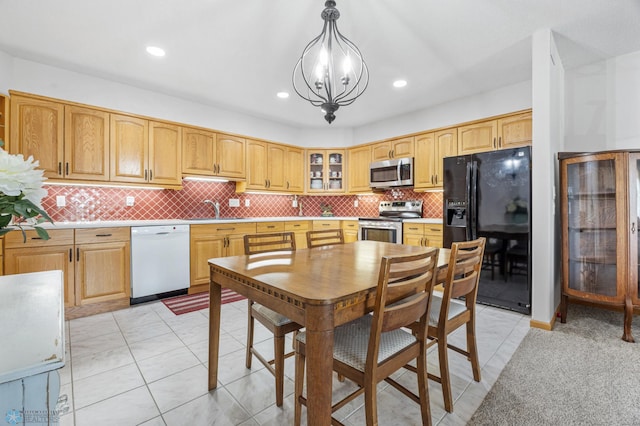 2501 30th Ave S Unit 203, Fargo, ND 58103 - kitchen featuring stainless steel appliances, glass insert cabinets, a chandelier, backsplash, and pendant lighting