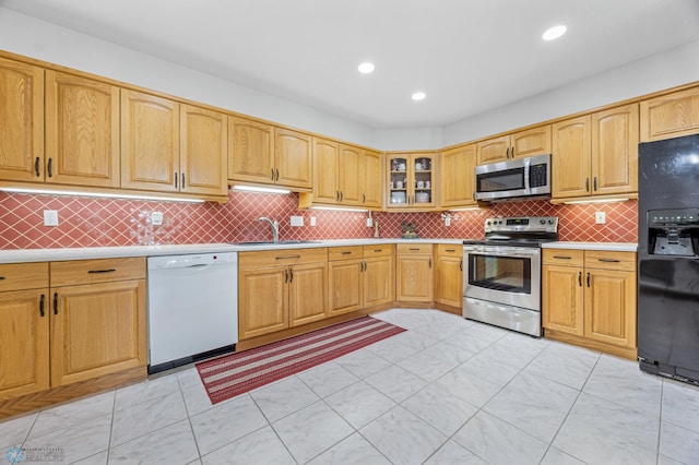 2501 30th Ave S Unit 203, Fargo, ND 58103 - kitchen with stainless steel appliances, light countertops, tasteful backsplash, glass insert cabinets, and recessed lighting