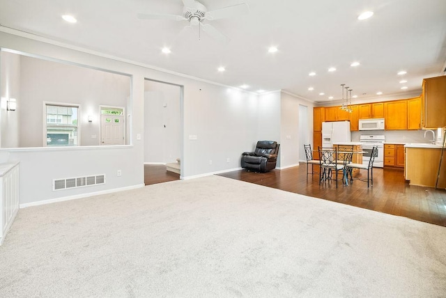 6800 Troy Ln N, Maple Grove, MN 55311 - kitchen featuring white appliances, ornamental molding, recessed lighting, open floor plan, and dark colored carpet