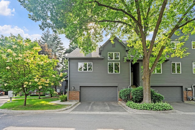 2212 Sherwood Ct, Minnetonka, MN 55305 - view of front facade with brick siding, a garage, roof with shingles, and asphalt driveway