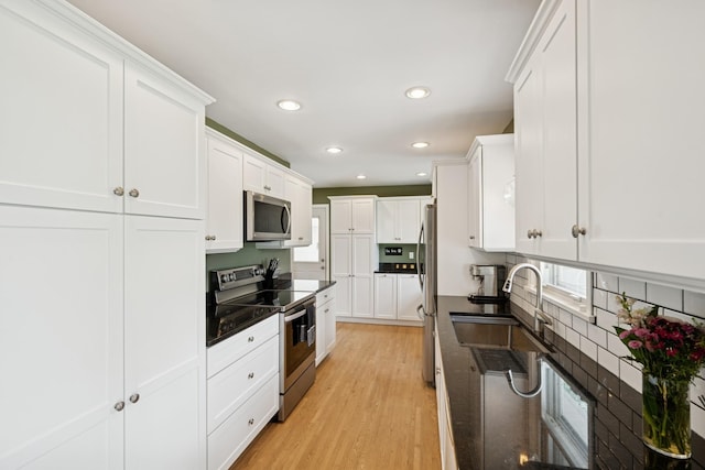3300 88th St, Bloomington, MN 55431 - kitchen with appliances with stainless steel finishes, recessed lighting, decorative backsplash, white cabinets, and light wood finished floors
