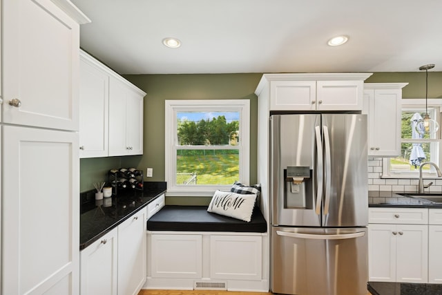 3300 88th St, Bloomington, MN 55431 - kitchen with stainless steel fridge with ice dispenser, white cabinetry, decorative backsplash, recessed lighting, and hanging light fixtures