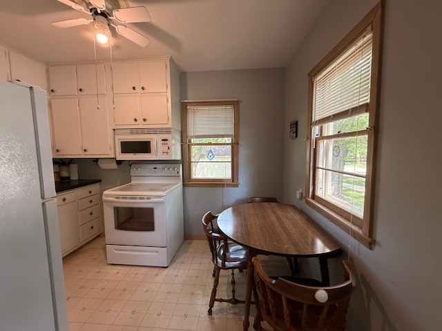 1202 4th St, Montevideo, MN 56265 - kitchen with white appliances, light flooring, white cabinets, and a ceiling fan