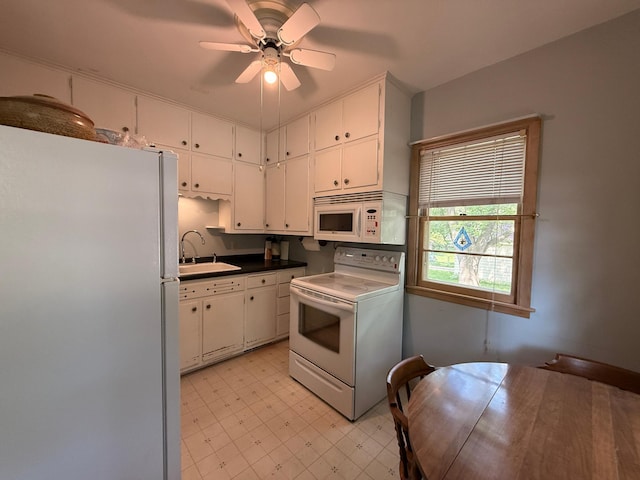 1202 4th St, Montevideo, MN 56265 - kitchen with white appliances, light floors, white cabinetry, ceiling fan, and dark countertops