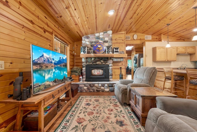 2630 320th St, Cushing, WI 54006 - living room featuring vaulted ceiling, wood walls, wood ceiling, wood finished floors, and a fireplace