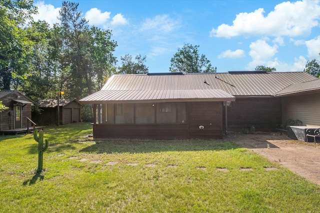 2630 320th St, Cushing, WI 54006 - rear view of property featuring a yard, a shed, a metal roof, and a sunroom