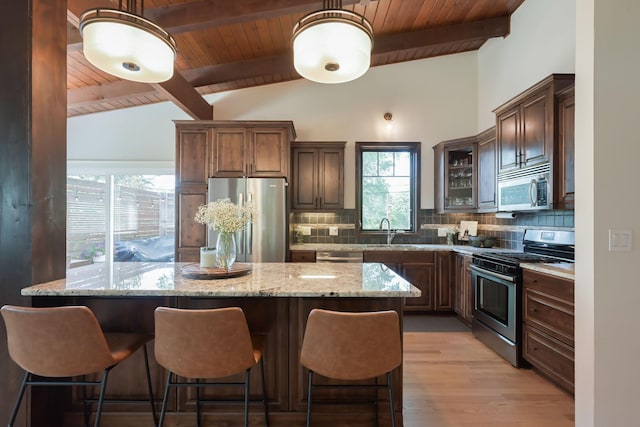 2820 Overlook Dr, Bloomington, MN 55431 - kitchen with appliances with stainless steel finishes, wood ceiling, backsplash, light stone counters, and a breakfast bar