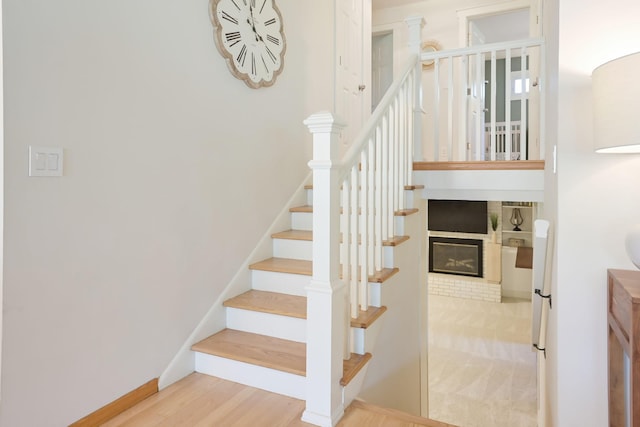 2820 Overlook Dr, Bloomington, MN 55431 - stairway featuring wood finished floors and a brick fireplace