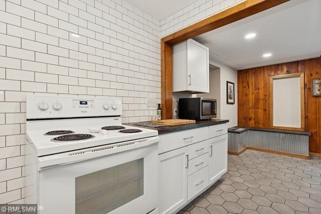 2818 Wilson Ave, Sterling Twp, WI 54024 - kitchen with white electric range, stainless steel microwave, white cabinetry, wood walls, and recessed lighting