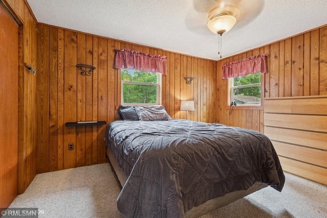 2818 Wilson Ave, Sterling Twp, WI 54024 - carpeted bedroom featuring multiple windows, wood walls, and a ceiling fan
