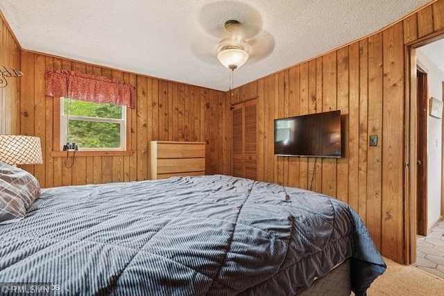 2818 Wilson Ave, Sterling Twp, WI 54024 - bedroom featuring wood walls, a closet, a textured ceiling, and a ceiling fan