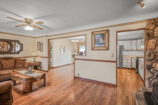 2233 Fremont Ave E, Saint Paul, MN 55119 - living area with a textured ceiling, light wood-style floors, a ceiling fan, crown molding, and a chandelier