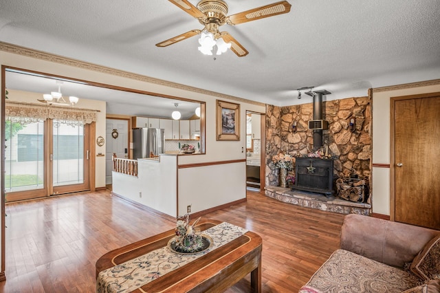 2233 Fremont Ave E, Saint Paul, MN 55119 - living area featuring a textured ceiling, light wood-style floors, ceiling fan, a wood stove, and a chandelier