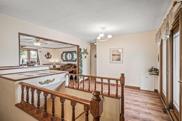 2233 Fremont Ave E, Saint Paul, MN 55119 - stairway with wood finished floors, a textured ceiling, and a chandelier