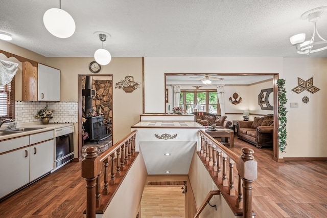 2233 Fremont Ave E, Saint Paul, MN 55119 - kitchen with dishwashing machine, a textured ceiling, wood finished floors, tasteful backsplash, and light countertops