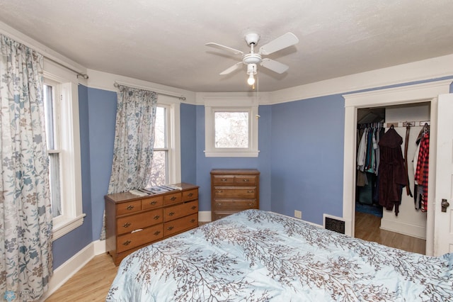 320 Elm St, Crookston, MN 56716 - bedroom with light wood-style flooring, a spacious closet, a closet, and ceiling fan