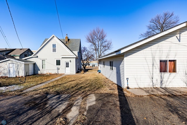 320 Elm St, Crookston, MN 56716 - view of property exterior featuring a storage shed and a chimney