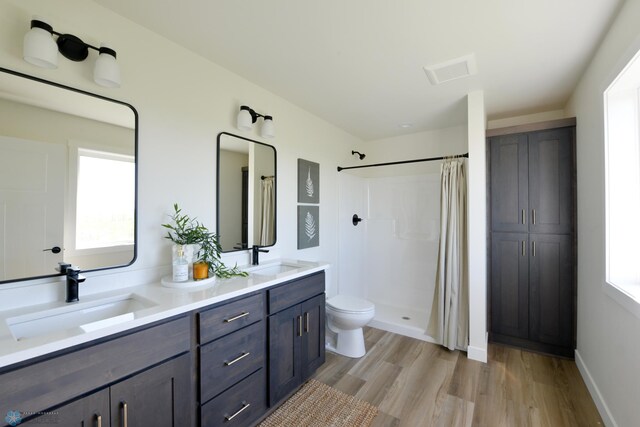 1276 Marlys Dr W, West Fargo, ND 58078 - full bathroom with wood finished floors, a shower with curtain, and double vanity