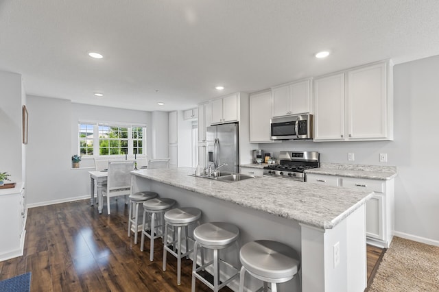 7558 Woods Edge Blvd, Lino Lakes, MN 55014 - kitchen with appliances with stainless steel finishes, white cabinetry, dark wood-type flooring, an island with sink, and recessed lighting
