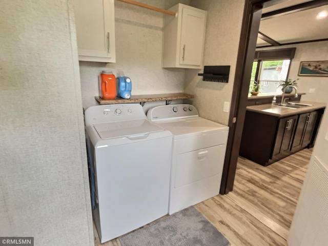 13648 Campfire Cir, South Haven, MN 55382 - laundry area with separate washer and dryer, light wood-type flooring, and cabinet space
