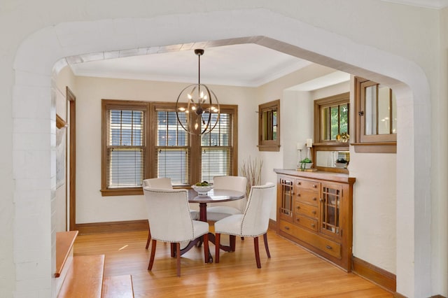 1339 Sargent Ave, Saint Paul, MN 55105 - dining room featuring a chandelier, light wood-style flooring, crown molding, and arched walkways