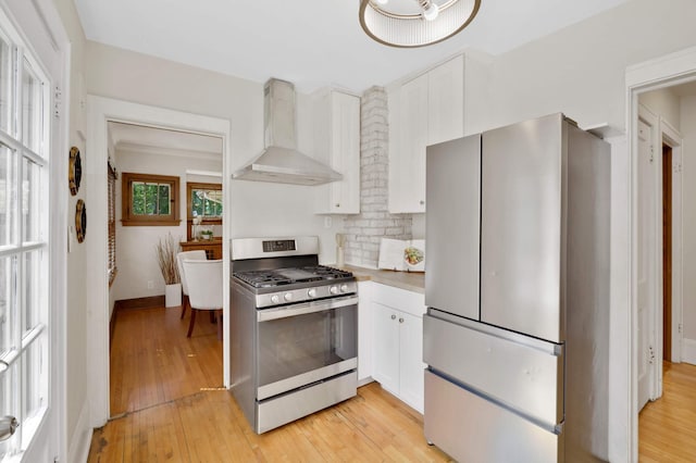 1339 Sargent Ave, Saint Paul, MN 55105 - kitchen featuring wall chimney range hood, appliances with stainless steel finishes, white cabinetry, light wood-style floors, and light countertops