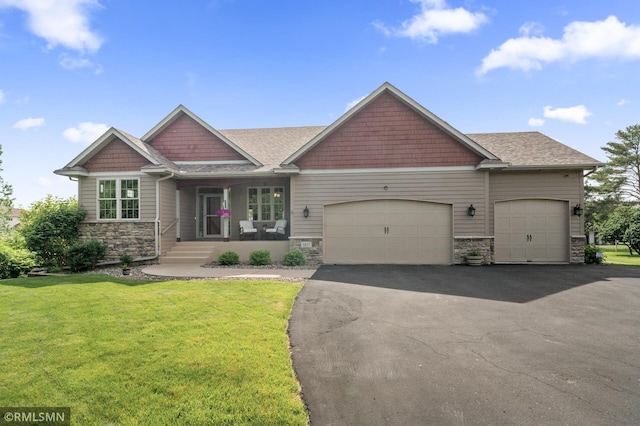 6831 Centerville Rd, Centerville, MN 55038 - craftsman-style home featuring stone siding, a garage, asphalt driveway, a front lawn, and covered porch