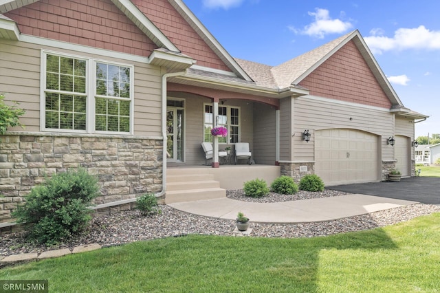 6831 Centerville Rd, Centerville, MN 55038 - craftsman-style house featuring covered porch, stone siding, a garage, driveway, and a shingled roof