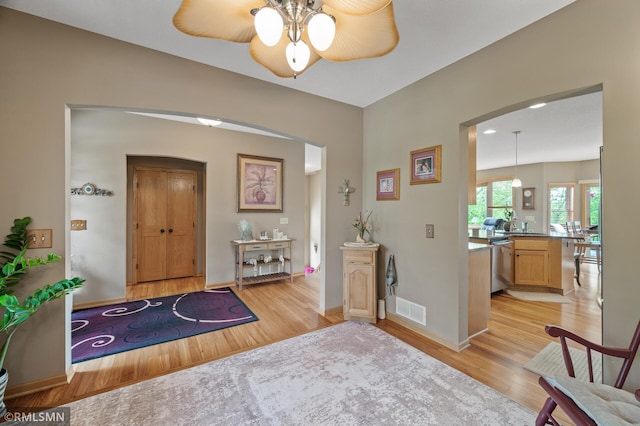 6831 Centerville Rd, Centerville, MN 55038 - foyer entrance with arched walkways, light wood-style floors, and a ceiling fan
