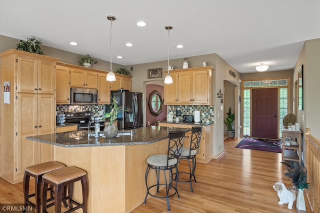 6831 Centerville Rd, Centerville, MN 55038 - kitchen with stainless steel appliances, a breakfast bar, light wood-style flooring, backsplash, and light brown cabinets