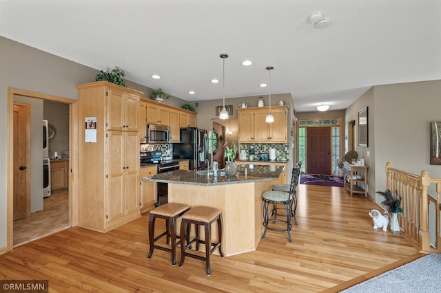 6831 Centerville Rd, Centerville, MN 55038 - kitchen featuring black appliances, a breakfast bar, light wood-type flooring, tasteful backsplash, and recessed lighting