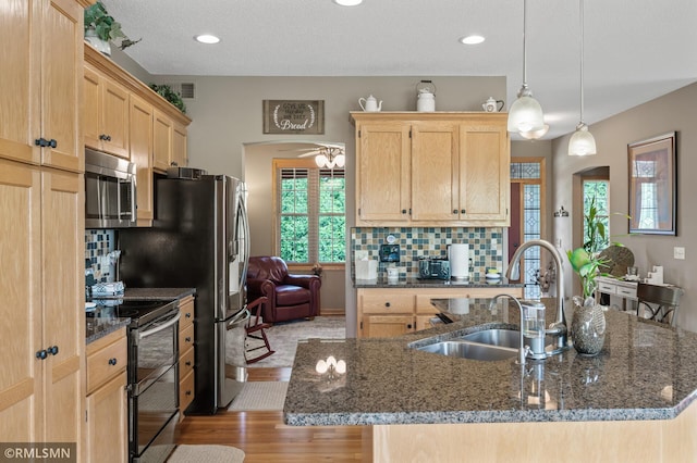 6831 Centerville Rd, Centerville, MN 55038 - kitchen with black / electric stove, stainless steel microwave, light brown cabinetry, light wood finished floors, and tasteful backsplash