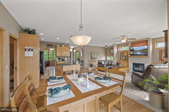 6831 Centerville Rd, Centerville, MN 55038 - dining area with healthy amount of natural light, a tile fireplace, ceiling fan, light wood-type flooring, and recessed lighting